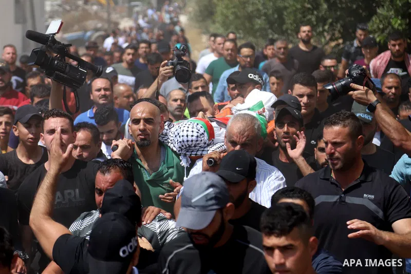 Mourners attend the funeral of Palestinian Shawkat Khalid Awad, 20, in the village of Beit Ummar, north of the West Bank City of Hebron, on July 30, 2021. - The Palestinian youth was killed by Israeli army gunfire in the...
