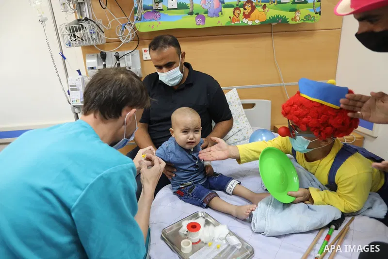 Palestinian clowns play with a child with cancer at el-Rantisi hospital in Gaza city on August 01, 2021. 2020 has been a rough year for cancer patients in the Gaza Strip. The usual restrictions and blockade were compound...
