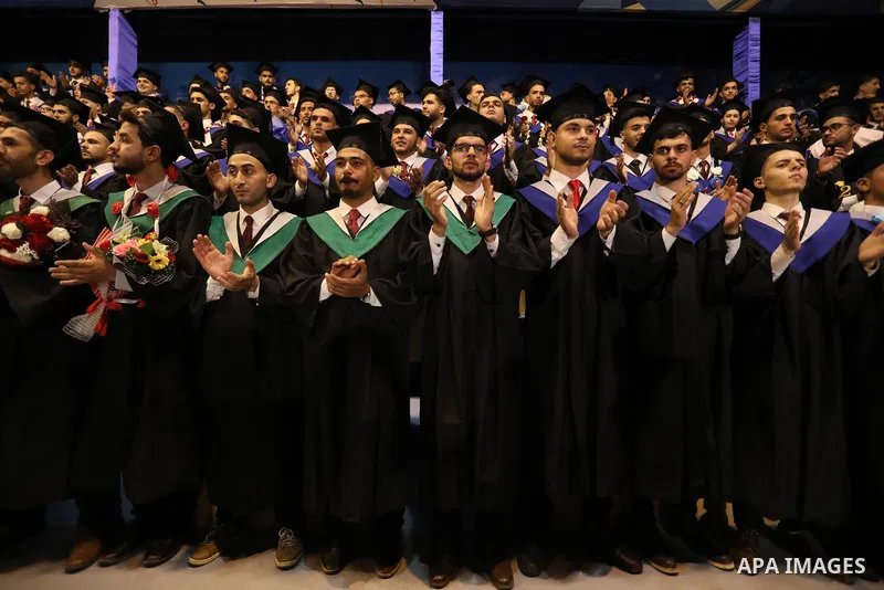 A picture taken on August 1, 2021 shows Palestinian students attend their graduation ceremony at University College of Applied Sciences (UCAS), in Gaza city. Photo by Ashraf Amra
