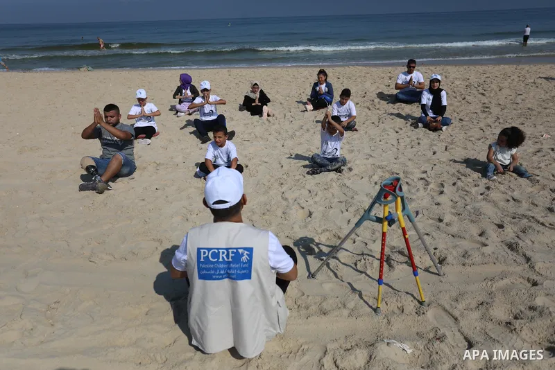 Palestinian children of special needs perform yoga, on a beach in Gaza City on August 2, 2021. The organization has launched on sunday the summer camp in the Middle East, which called "Camp Ability" for children with amp...