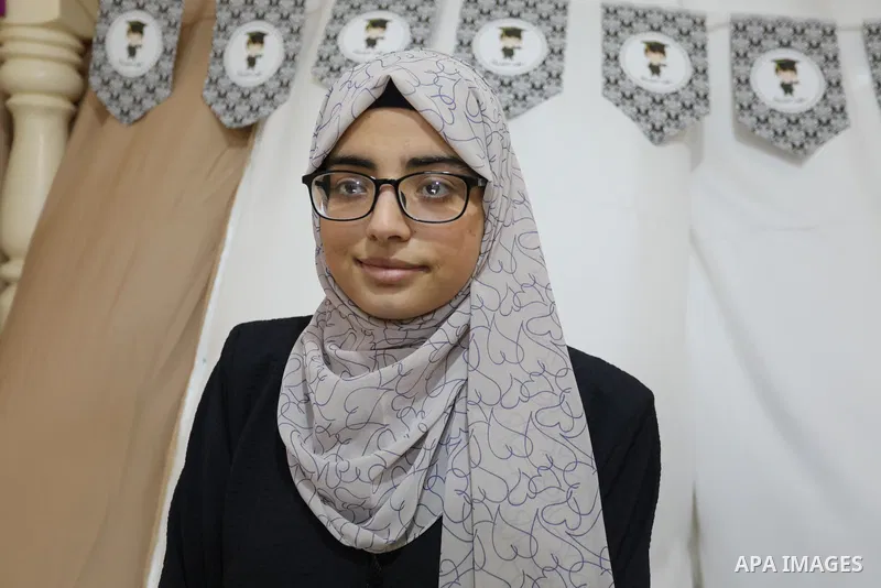 A Palestinian high school students Wafaa Amjd, 99.1%, who destroyed her family's home during the recent conflict between Israel and Hamas, celebrates with her family after her success in the final exams known as "Tawjihi...