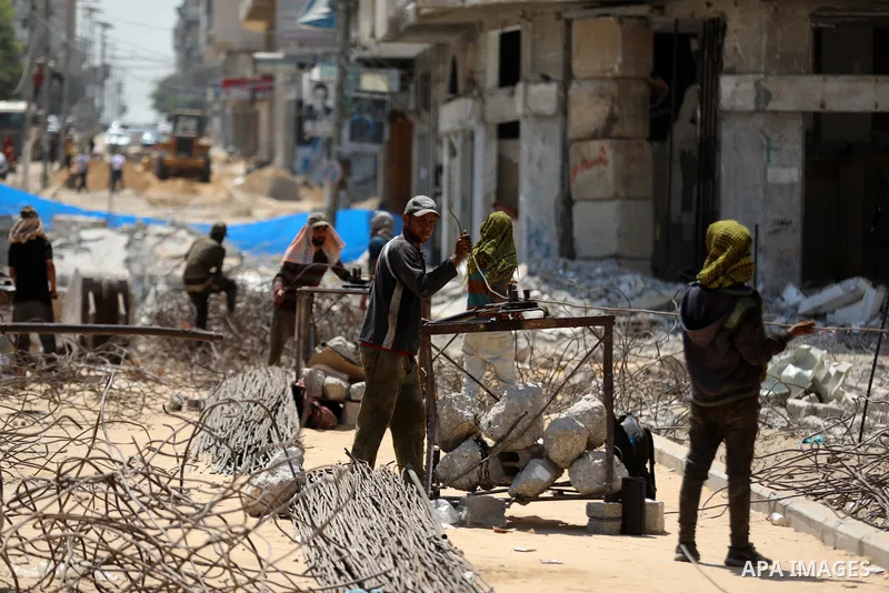 Palestinian workers remove the rubble of al-Da'our building damaged by Israeli air strikes during the recent 11-days conflict between Isarel and Hamas on May, in Gaza city on August 4, 2021. Photo by Mahmoud Nasser
