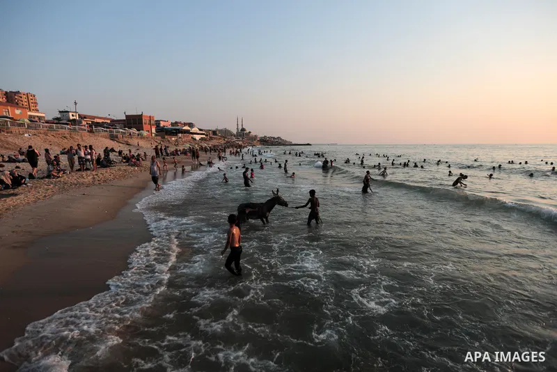 Palestinians enjoy their time at the beach of Gaza sea during a hot day on August 6, 2021. The beach is one of the few open public spaces in this densely populated city. Photo by Mohammed Dahman