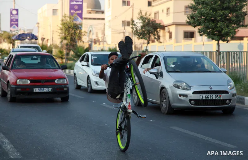 Palestinian youths show their skills while riding bicycles in Gaza city on August 6, 2021. Photo by Omar Ashtawy