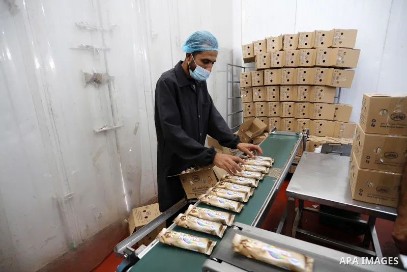 Palestinian workers work inside an ice cream factory in Gaza city, on August 8, 2021. The owners of ice-cream factories in the Gaza Strip suffer from a lack of production during the most demanding seasons during the summ...