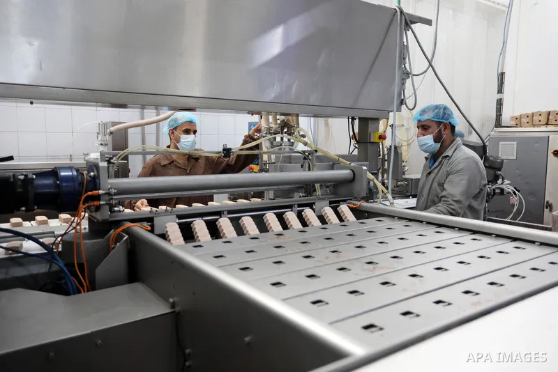 Palestinian workers work inside an ice cream factory in Gaza city, on August 8, 2021. The owners of ice-cream factories in the Gaza Strip suffer from a lack of production during the most demanding seasons during the summ...
