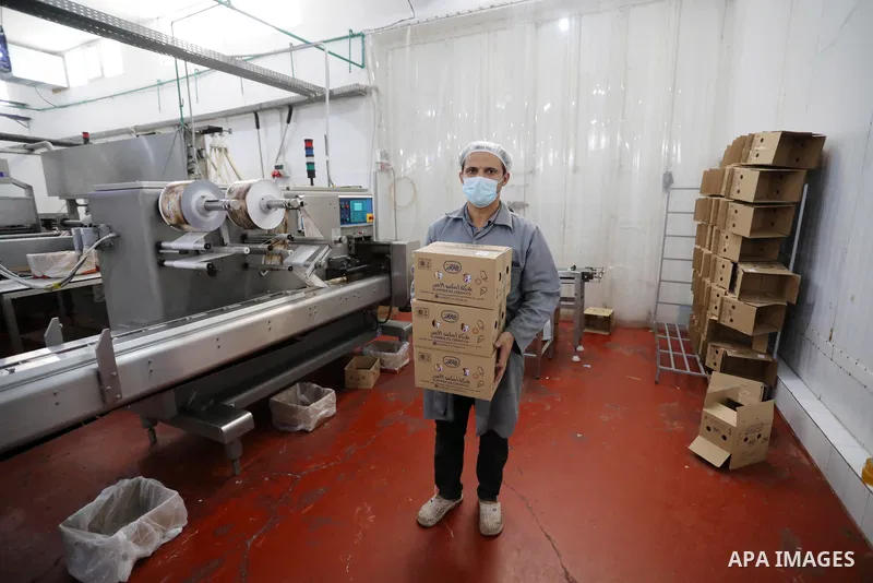Palestinian workers work inside an ice cream factory in Gaza city, on August 8, 2021. The owners of ice-cream factories in the Gaza Strip suffer from a lack of production during the most demanding seasons during the summ...