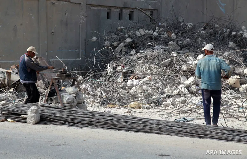 Palestinian workers remove the rubble of Jala' Tower recently destroyed by Israeli strikes in Gaza City, on August 8, 2021. Al-Sisi also promised $500 million for rebuilding Gaza, and gave directives to Egyptian state in...