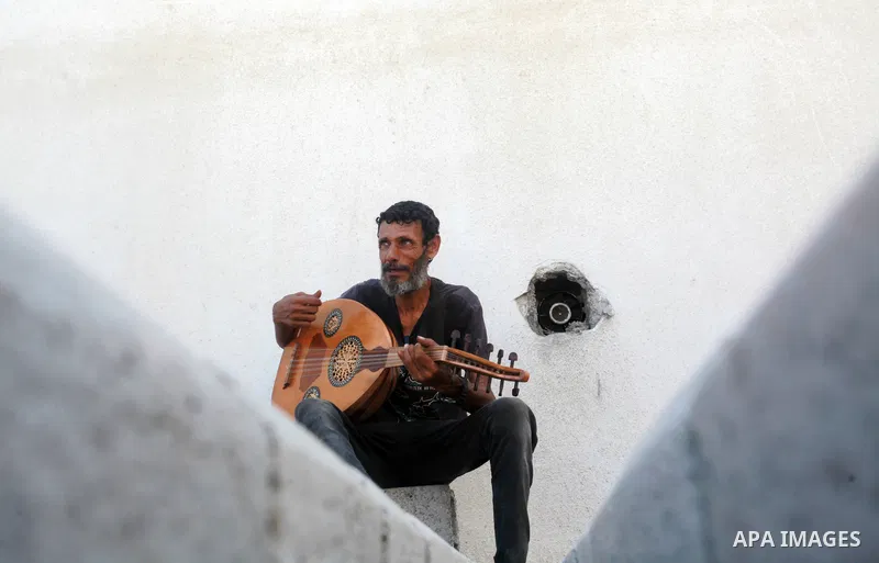 Palestinian refugee, Kamal Abu Ghabin, 57, plays the lute known in Arabic as an "Oud", during his rest, in Gaza city, on August 8, 2021. Abu Ghabin works as a blacksmith and has been playing the oud since his childhood....