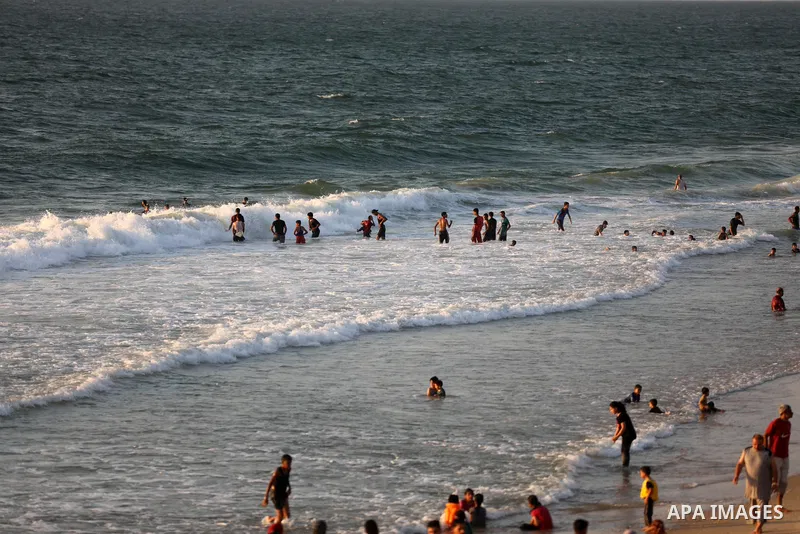 Palestinians enjoy their time at the beach of Deir al-Balah sea, in the center of Gaza Strip, during a hot day on August 10, 2021. The beach is one of the few open public spaces in this densely populated city. Photo by A...