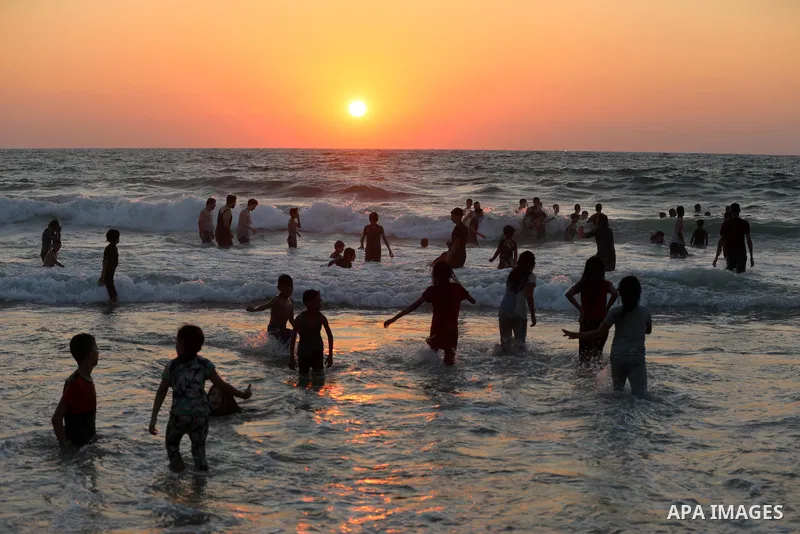 Palestinians enjoy their time at the beach of Deir al-Balah sea, in the center of Gaza Strip, during a hot day on August 10, 2021. The beach is one of the few open public spaces in this densely populated city. Photo by A...