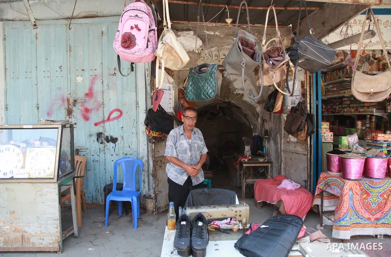 Palestinian tailor Khalil Hamdan, 64, ​re-sewing worn out shoes and bags for students before the start of the new school year, in light of difficult economic and living conditions for Gazans, at al-Zawya market in Gaza c...