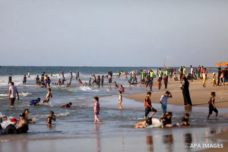 Palestinians enjoy their time at the beach of Deir al-Balah sea, in the center of Gaza Strip, during a hot day on August 11, 2021. The beach is one of the few open public spaces in this densely populated city. Photo by A...