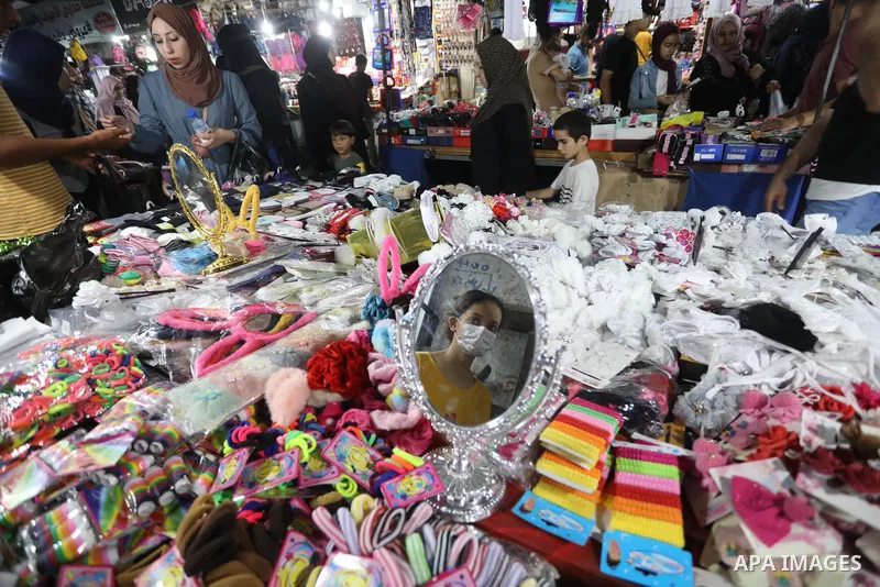 Palestinians shop during preparation for the new school year at a market in Nuseirat refugee camp in the center of the Gaza Strip, on 11 August 2021. The fiscal position in Gaza strip has worsened not only due to the out...