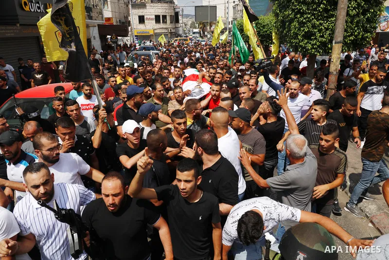 Palestinian mourners carry the body of Deyaa Sabarini, 25, who was died of his wounds after he was shot by Israeli forces last week, during his funeral, in the West Bank city of Jenin on August 12, 2021. Photo by Oday Da...