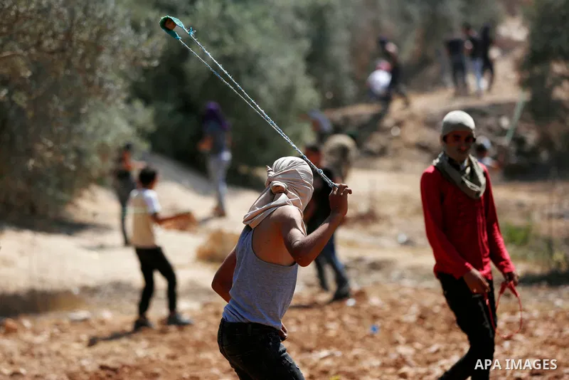 Palestinian protesters clash with Israeli forces during a demonstration against the Israeli settlers' outpost of Eviatar, in the town of Beita, near the West Bank city of Nablus, on August 13, 2021. Photo by Shadi Jarar'...