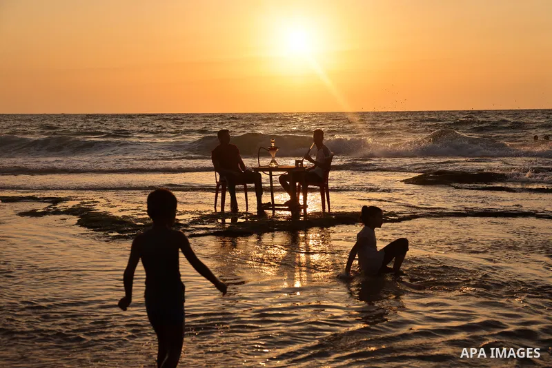 Palestinians enjoy their time at the beach of Deir al-Balah sea, in the center of Gaza Strip, during a hot day on August 13, 2021. The beach is one of the few open public spaces in this densely populated city. Photo by O...
