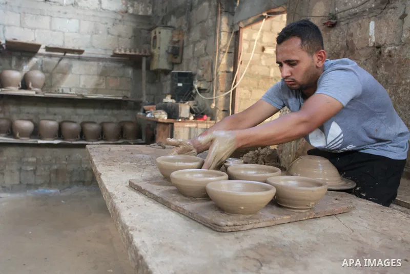 A Palestinian pottery worker makes earthenware vases at a pottery workshop, in Gaza city on August 23, 2021. Pottery is an ancient and traditional craft in Gaza. Local workshops usually produce products such as bowls, pi...