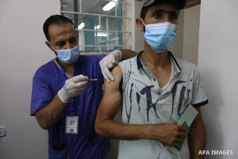 Palestinians get inoculated with a dose of the Covishield vaccine against the Covid-19 coronavirus, at a temporary vaccination centre set up, in Deir Al Balah in the center of Gaza strip on August 26, 2021. Minister of H...