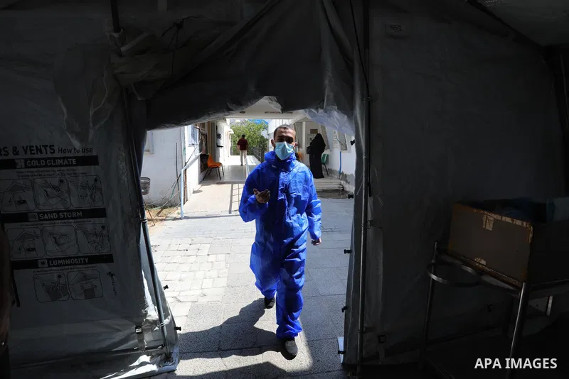 A Palestinian health worker collects a swab sample from a person for Covid-19 test, at a temporary vaccination centre set up, in Deir Al Balah in the center of Gaza strip on August 26, 2021. Three people have died of cor...