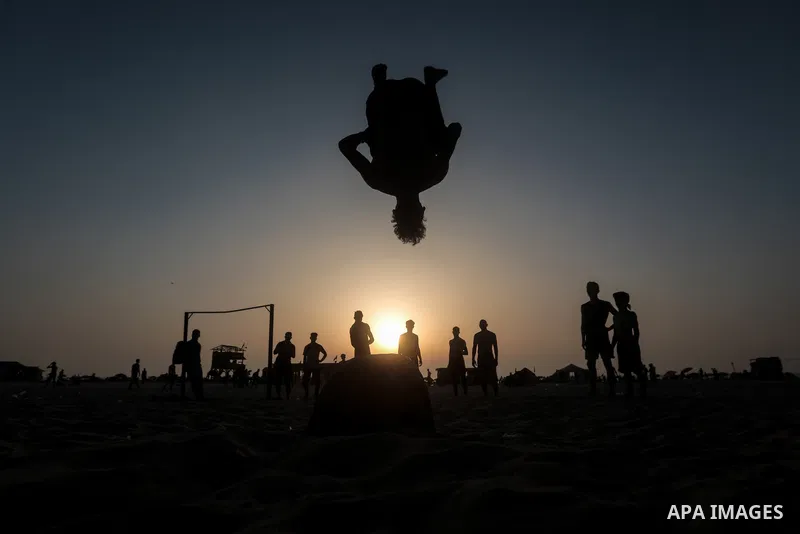 A Palestinian man practises parkour at the beach in Gaza City on July 02, 2021. Photo by Mohammed Dahman