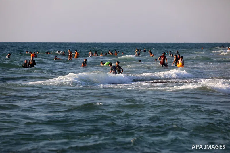 Palestinians enjoy the beach of the Mediterranean sea in Deir al-Balah in the center of Gaza Strip, on July 09, 2021. The beach is one of the few open public spaces in this densely populated city. Photo by Ashraf Amra