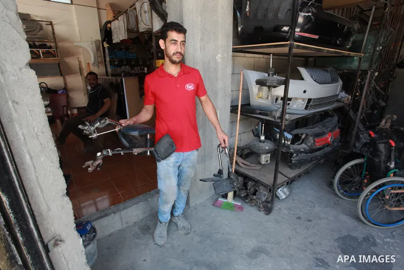 Palestinian youths work in wheelchairs repair at their workshop, in Gaza City, on July 10, 2021. A youth initiative to repair wheelchairs for people with disabilities free of charge in the Gaza Strip. 93 Thousands Person...