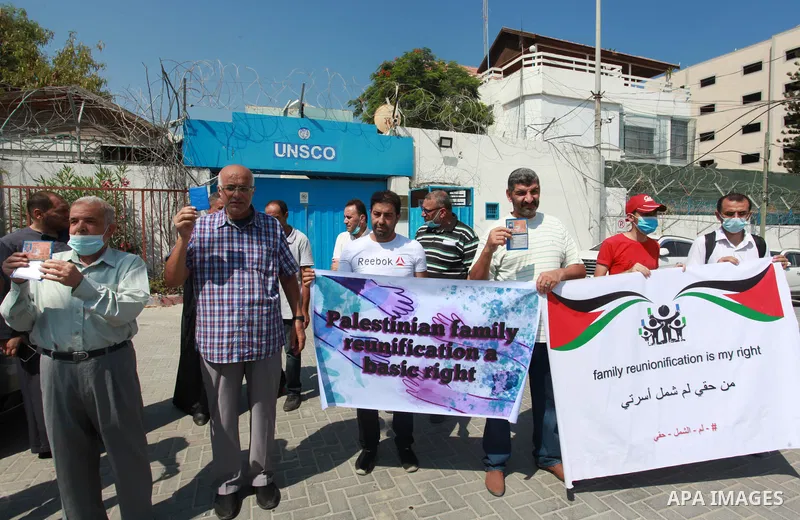 Palestinians hold IDs and banners to demand of the family unification, in front of the headquarter United Nation "UNSCO" in Gaza city, on July 11 2021. Israeli laws and policies prevent the reunification of families betw...