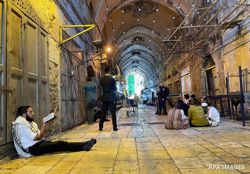 A group of ultra-Orthodox Jewish men pray outside the al-Aqsa mosque compound in Jerusalem, as Israeli security forces stand guard at a closure, during the annual Tisha B'Av (Ninth of Av) fasting and memorial day, commem...