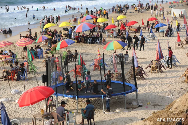 Palestinians enjoy the beach of the Mediterranean sea in Deir al-Balah in the center of Gaza Strip, during the fourth day of Eid al-adha festival on July 23, 2021. The al-Adha, or "Feast of Sacrifice", marks the end of t...