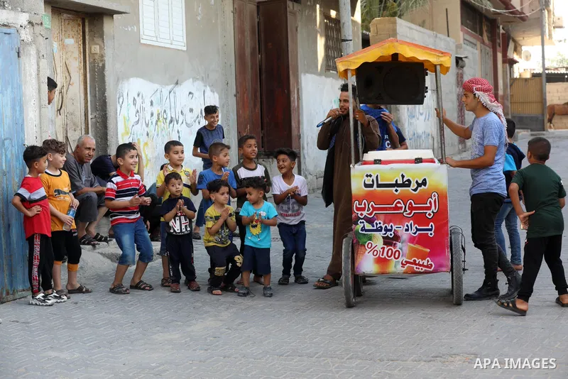 Palestinian singer and vendor Ahmed al-Haj, sells sundae on a cart at streets as he sings traditional songs in Nuseirat in the center of Gaza Strip, on July 25, 2021. Al-Haj, a singer and sundae vendor said that he combi...
