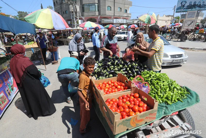 . Photo by Ashraf Amra Palestinians shop at a weekly market in Deir al-Balah in the center of Gaza Strip on June 29, 2021. The authorities in Gaza Strip decided to reopen the popular markets, after its closure, due to th...