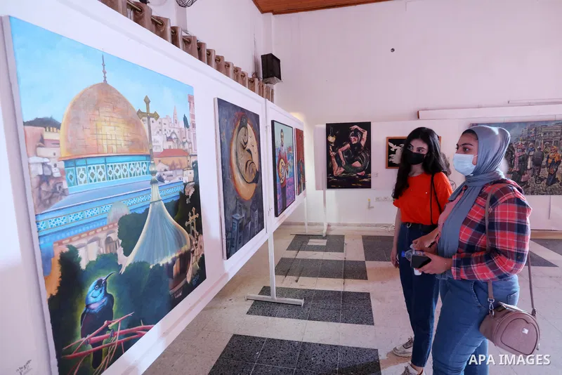 Palestinians attend an exhibition of paintings and sculptures, organized by the Gaza Center for Culture and Arts Association "The Third Gaza Contemporary Visual Arts Festival 2021" in Gaza City, on June 28, 2021. Photo b...