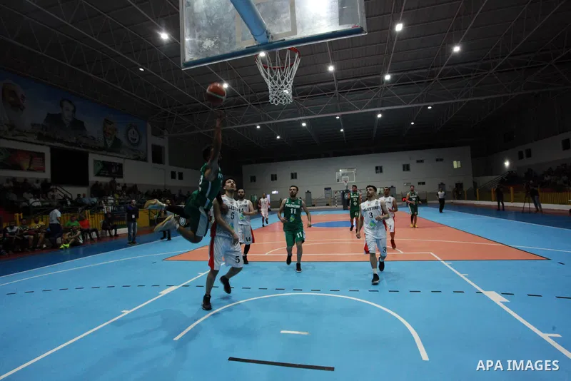 Palestinian basketball players of Khadamat al-Burij club (whiteT-shirt) and khadamat Rafah (greenT-shirt) compete during a super Cup, in Gaza City on June 25, 2021. Photo by Ali Hamad