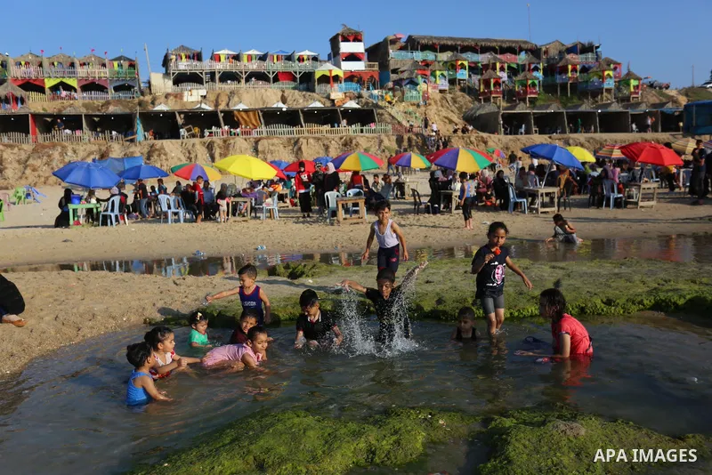 Palestinians enjoy their time on huts overlooking the beach of the Mediterranean sea in Deir al-Balah in the center of Gaza Strip, on June 25, 2021. The beach is one of the few open public spaces in this densely populate...