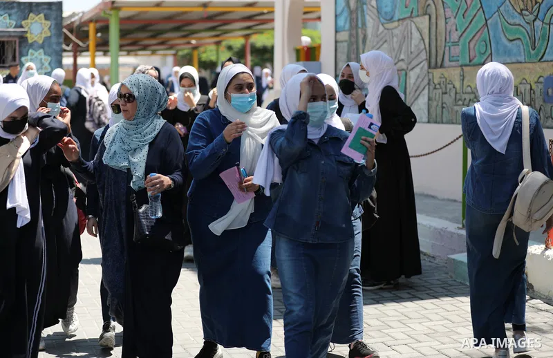 Palestinian students stand outside their school after completing the final high school exam, in Gaza City on June 24, 2021,amid concerns about the spread of the novel coronavirus pandemic. More than 84598 students in the...