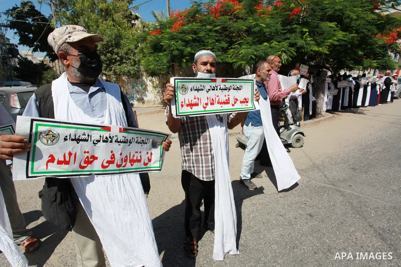 Families of Palestinian martyrs and wounded, take part in a protest against the Palestinian Authority's decision to cut their salaries for seven years, in front of the headquarters of Red cross in Gaza city, on June 21,...