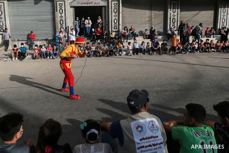 Palestinian children cheer during a mental health support session by Palestinian clowns in Gaza city on June 11, 2021. As Gaza tries to recover from the deadly 11-day Israeli attack, mothers and mental health workers hav...