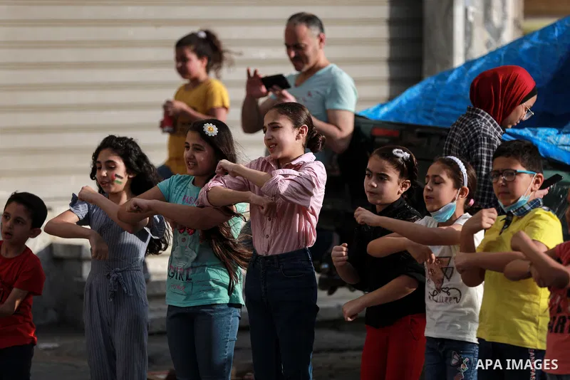 Palestinian children cheer during a mental health support session by Palestinian clowns in Gaza city on June 11, 2021. As Gaza tries to recover from the deadly 11-day Israeli attack, mothers and mental health workers hav...