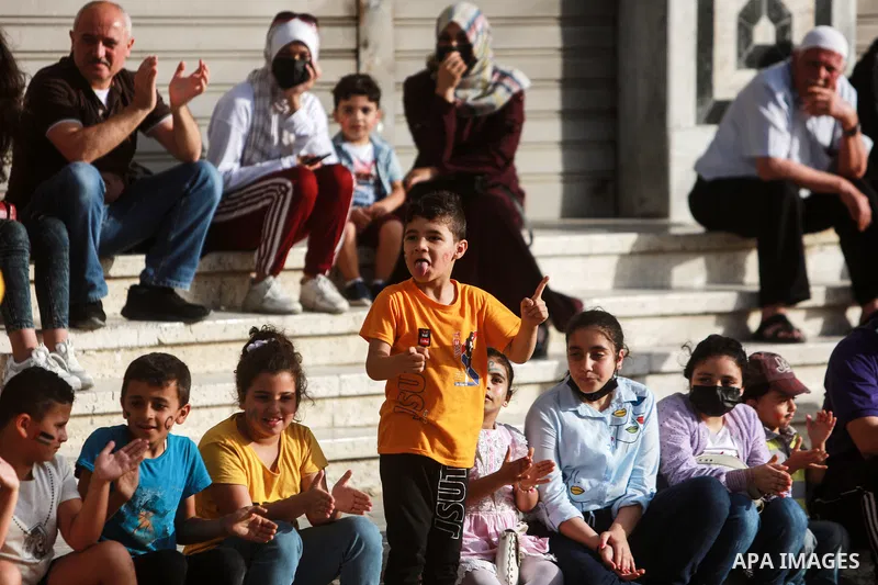 Palestinian children cheer during a mental health support session by Palestinian clowns in Gaza city on June 11, 2021. As Gaza tries to recover from the deadly 11-day Israeli attack, mothers and mental health workers hav...
