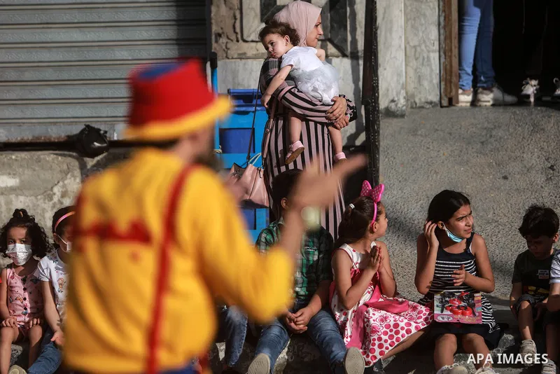 Palestinian children cheer during a mental health support session by Palestinian clowns in Gaza city on June 11, 2021. As Gaza tries to recover from the deadly 11-day Israeli attack, mothers and mental health workers hav...