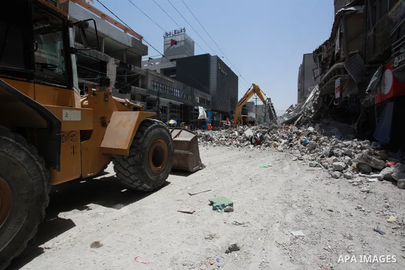 Egyptian workers and bulldozers sent from Egypt help to remove the rubble of Shorouq tower destroyed by Israeli air strikes last month in Gaza City on June 10, 2021. After brokering a ceasefire between the Israelis and H...