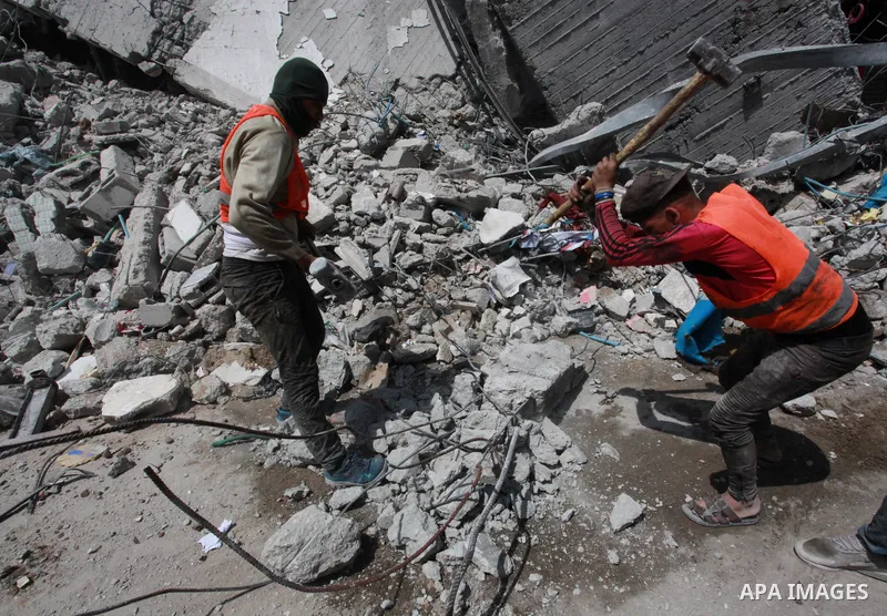 Egyptian workers and bulldozers sent from Egypt help to remove the rubble of Shorouq tower destroyed by Israeli air strikes last month in Gaza City on June 10, 2021. After brokering a ceasefire between the Israelis and H...