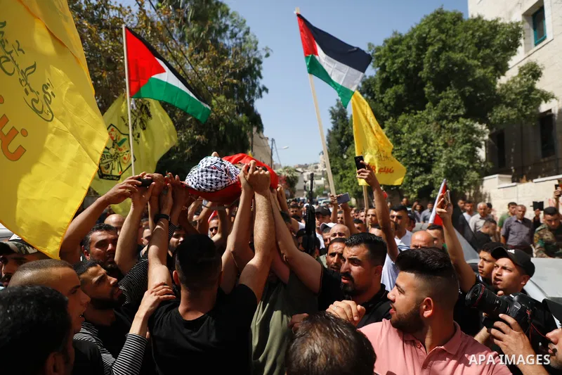 Mourners carry the body of Palestinian security man Tayseer Issa, who was killed by Israeli forces according to health ministry, during his funeral in the Werst bank city of Jenin, on June 10, 2021. Photo by Oday Daibes