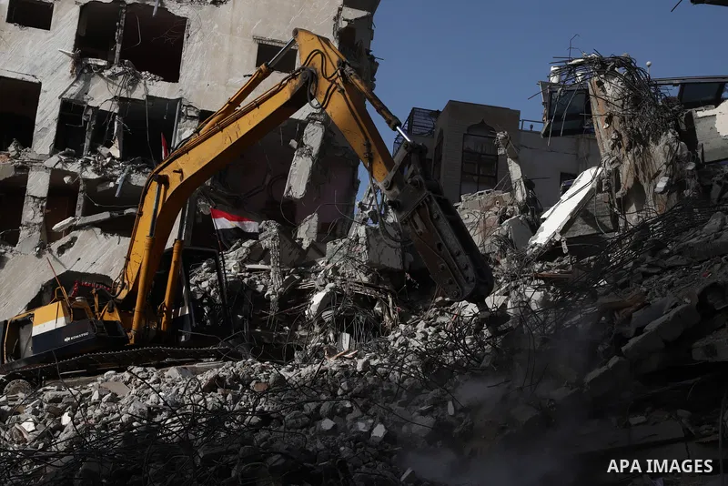 Palestinian workers and bulldozers remove the rubble of Hanadi Tower destroyed by Israeli air strikes last month, in Gaza city on June 9, 2021. Gaza’s housing ministry said on Thursday that 16,800 housing units had been...