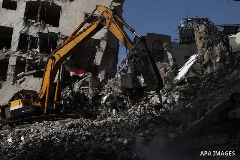 Palestinian workers and bulldozers remove the rubble of Hanadi Tower destroyed by Israeli air strikes last month, in Gaza city on June 9, 2021. Gaza’s housing ministry said on Thursday that 16,800 housing units had been...