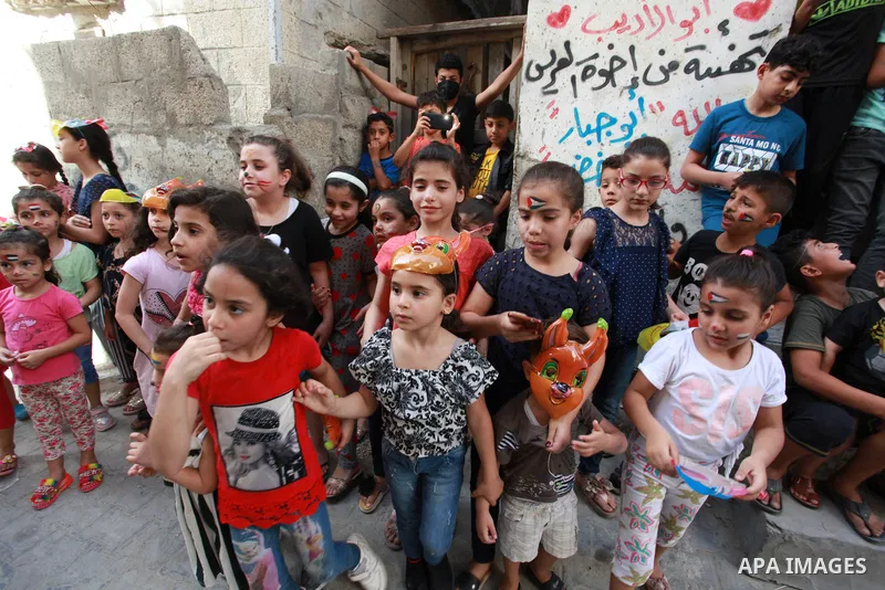 Palestinian children cheer during a mental health support session by Palestinian volunteers through acrobatic performances in Gaza city on June 9, 2021. As Gaza tries to recover from the deadly 11-day Israeli attack, mot...