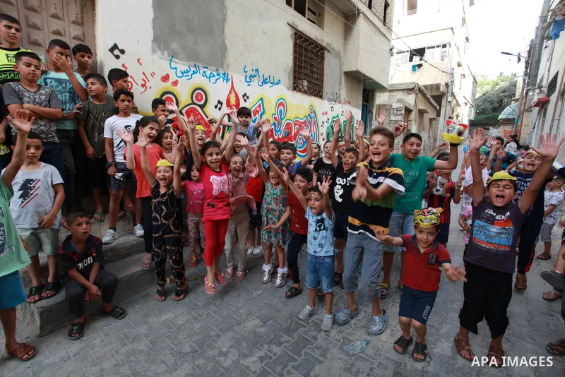 Palestinian children cheer during a mental health support session by Palestinian volunteers through acrobatic performances in Gaza city on June 9, 2021. As Gaza tries to recover from the deadly 11-day Israeli attack, mot...