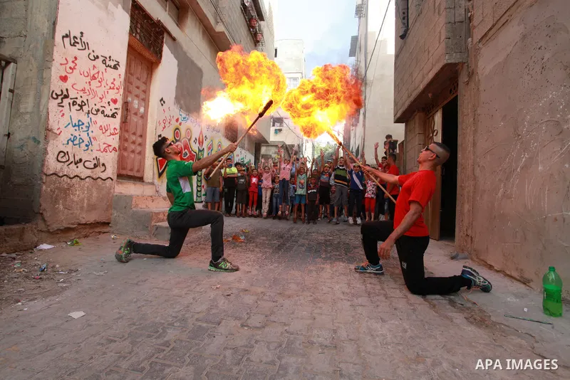 Palestinian volunteers perform acrobatic show in front of children during a mental health support session in Gaza city on June 9, 2021. As Gaza tries to recover from the deadly 11-day Israeli attack, mothers and mental h...