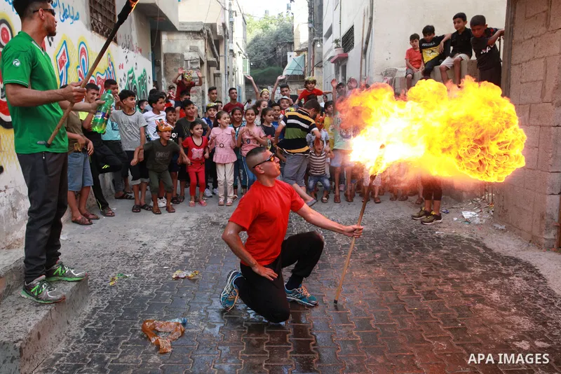 Palestinian volunteers perform acrobatic show in front of children during a mental health support session in Gaza city on June 9, 2021. As Gaza tries to recover from the deadly 11-day Israeli attack, mothers and mental h...